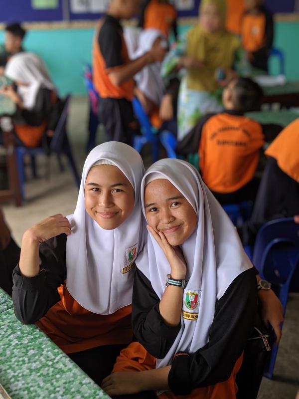 Seventh-graders Ellya, left, and Dayang. Women don’t have to wear their hijab outside of school, but many do, Kammerer said.